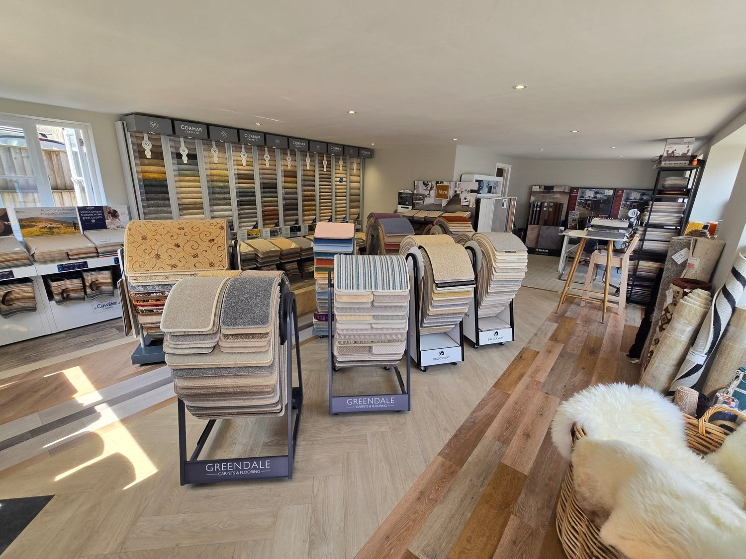 A wide interior showroom view of the Ottery flooring Company with carpet and LVT displays